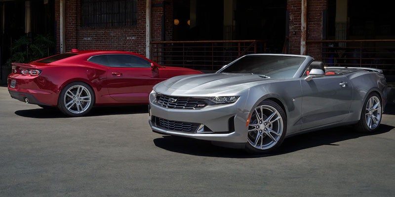 Red and silver chevy camaros parked side by side