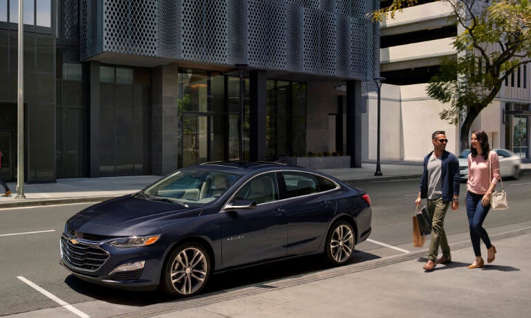 2024 Chevy Malibu Exterior Parked Near Sidewalk With Couple